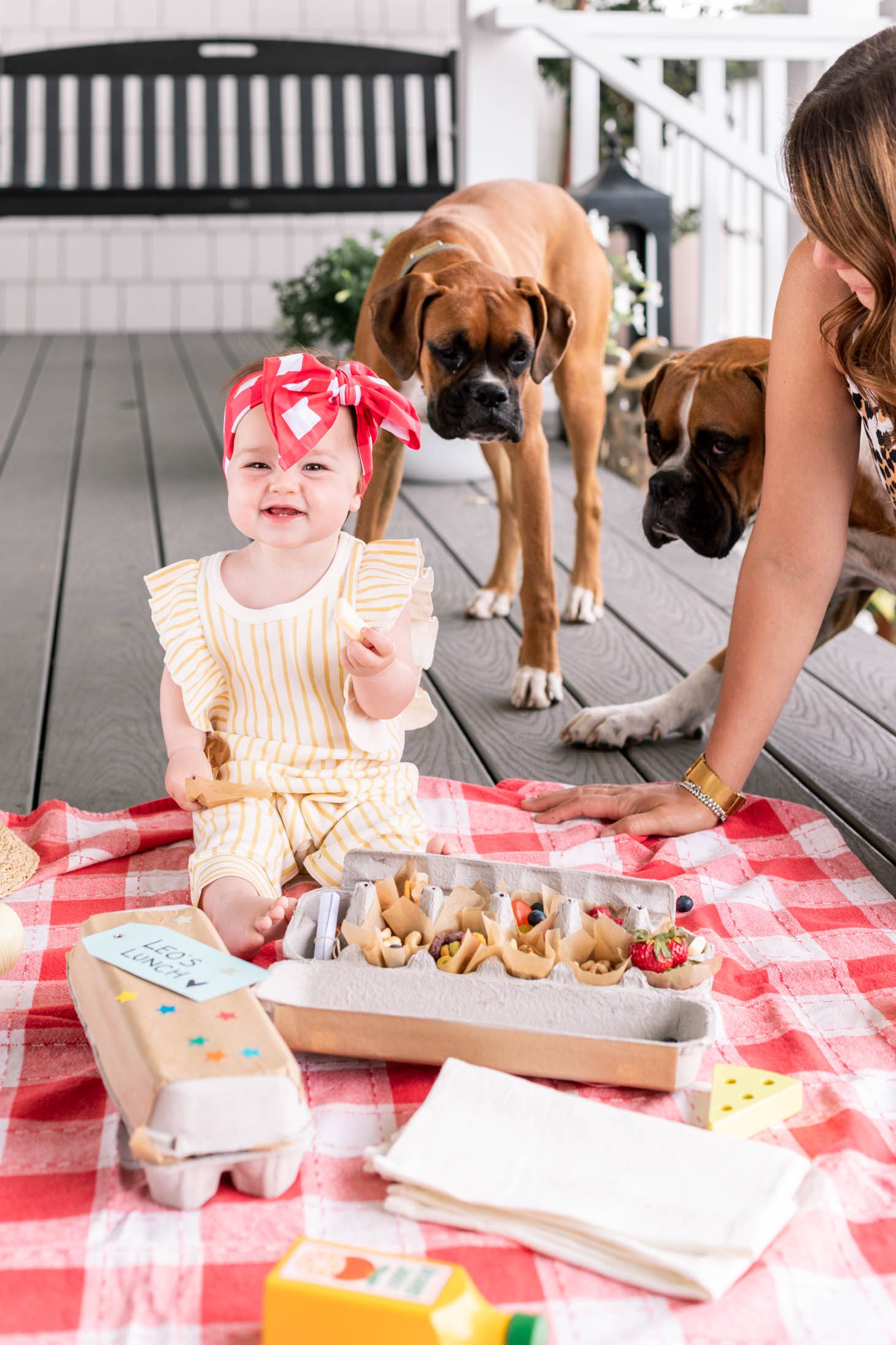 Jillian Harris' daughter Annie wearing a yellow striped jumper and holding a piece of cheese. 