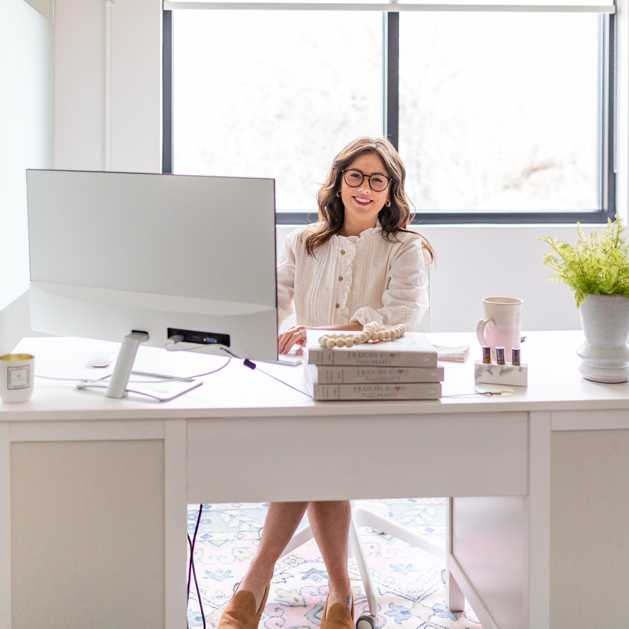 Jillian Harris behind desk for The Jilly Academy!