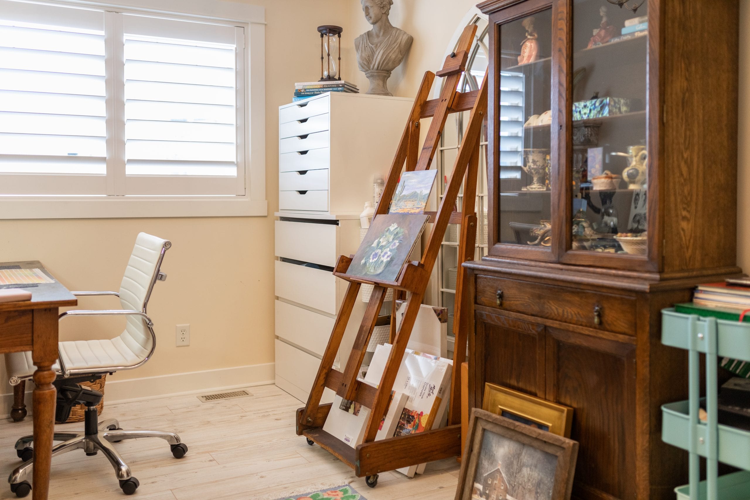 Peggy, Jillian Harris' mother's easel set up in her office with a painting of flowers on the easel. 