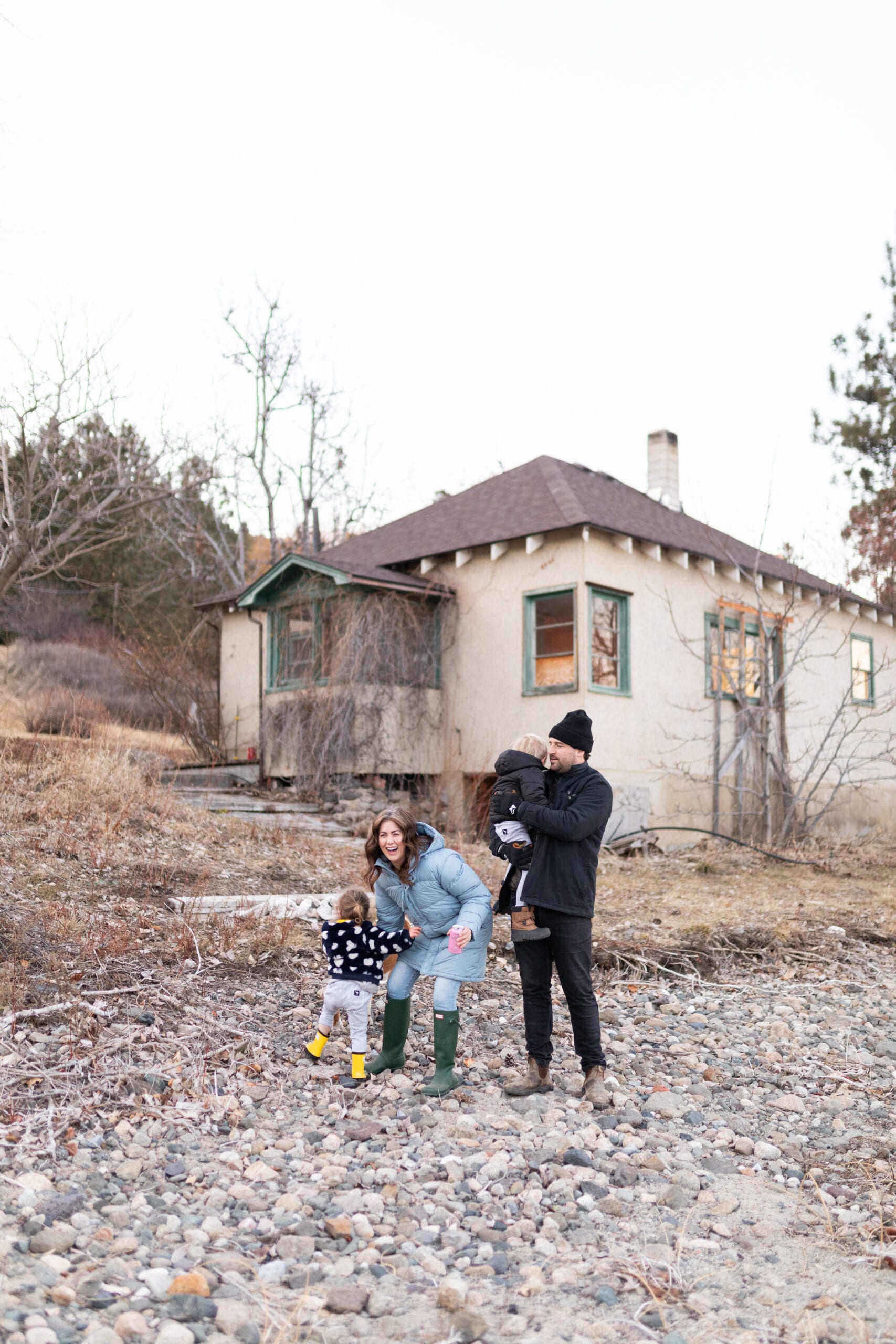 Jillian, Justin and their children out in front of the farmhouse before renovations.