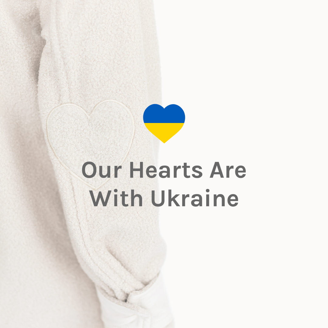 A photo of the Jillian Harris Scholar Shacket sleeve with a heart in the Ukraine colours above the words Our Hearts Are With Ukraine