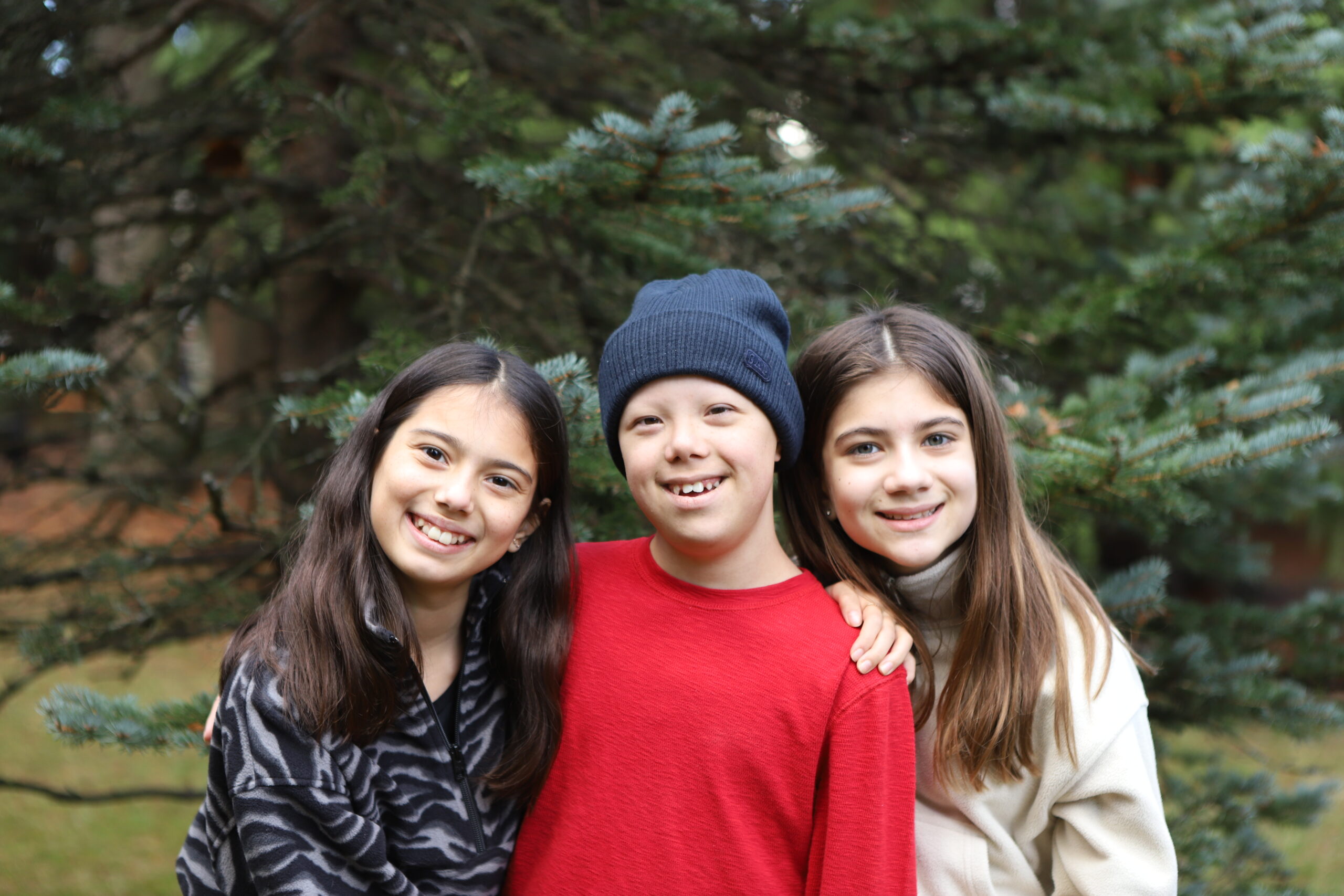 Beckett and his two sisters smiling at the camera