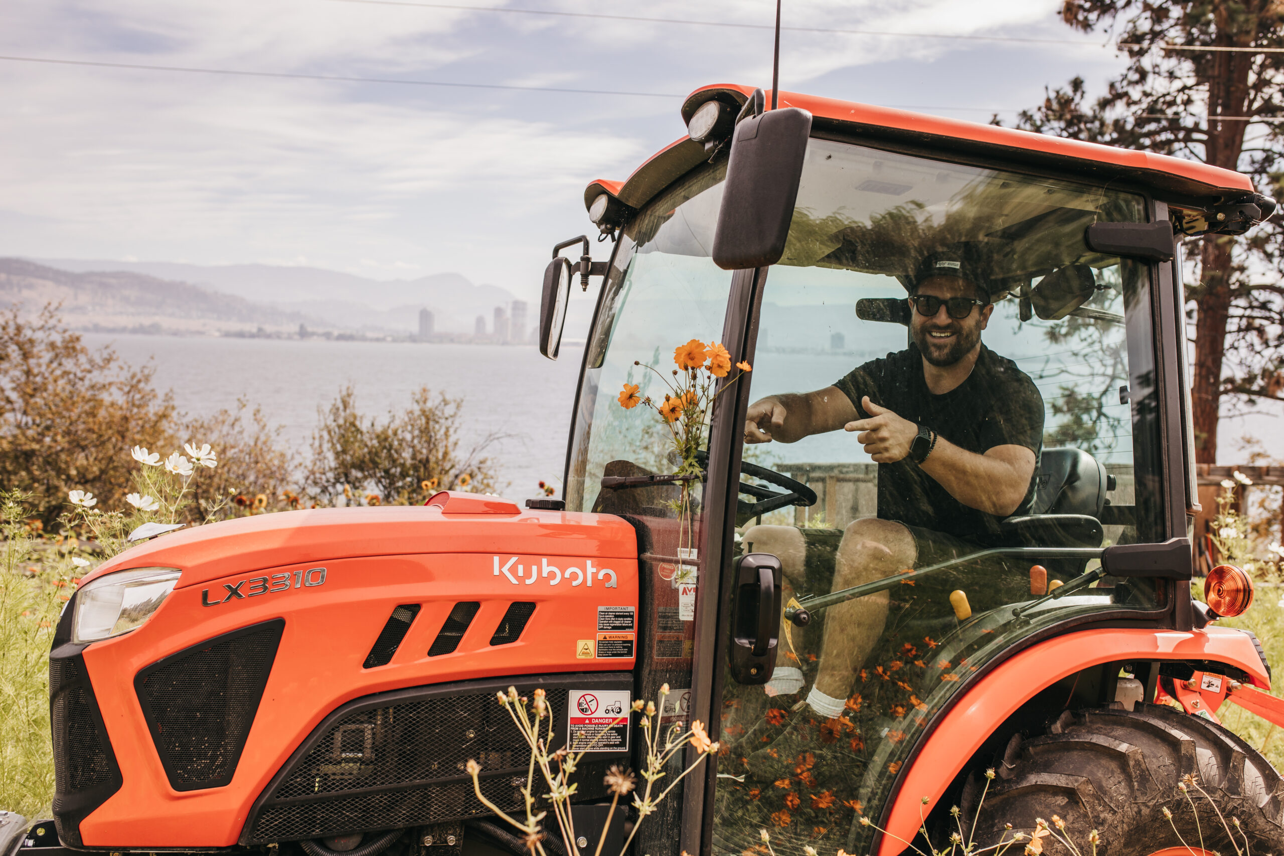 Justin Pasutto smiling in his Kubota tractor at the flower farm