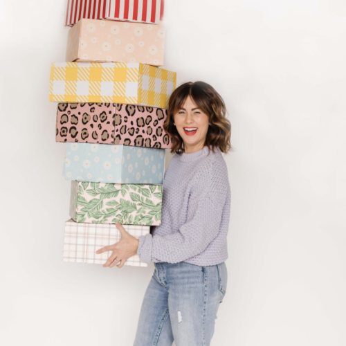 Jillian Harris with stack of past Jilly Boxes