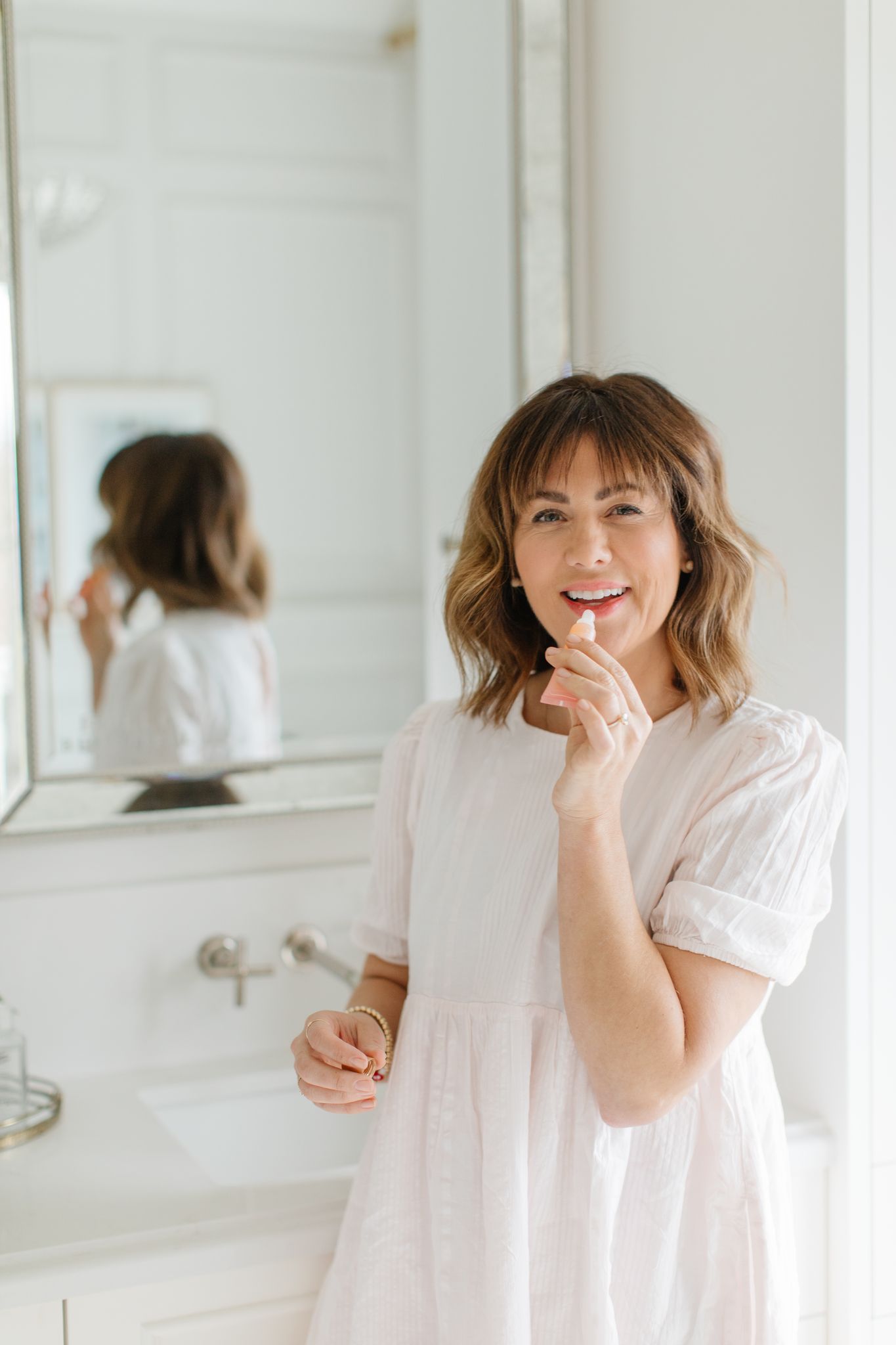 Jillian Harris putting on the BIOSSANCE Lip Blam included in the Summer 2022 Jilly Box!