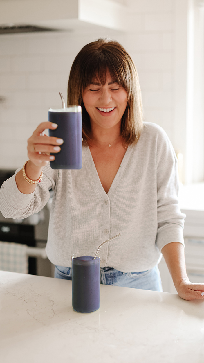 Jillian Harris in her kitchen holding the blueberry smoothie as part of the brain food recipes. 