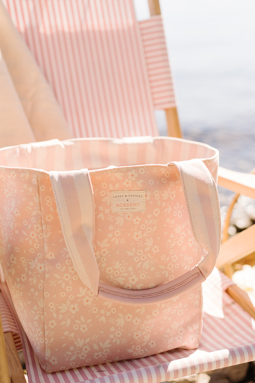 Poppy and Peonies reversible bag sitting on a beach chair lakeside. 