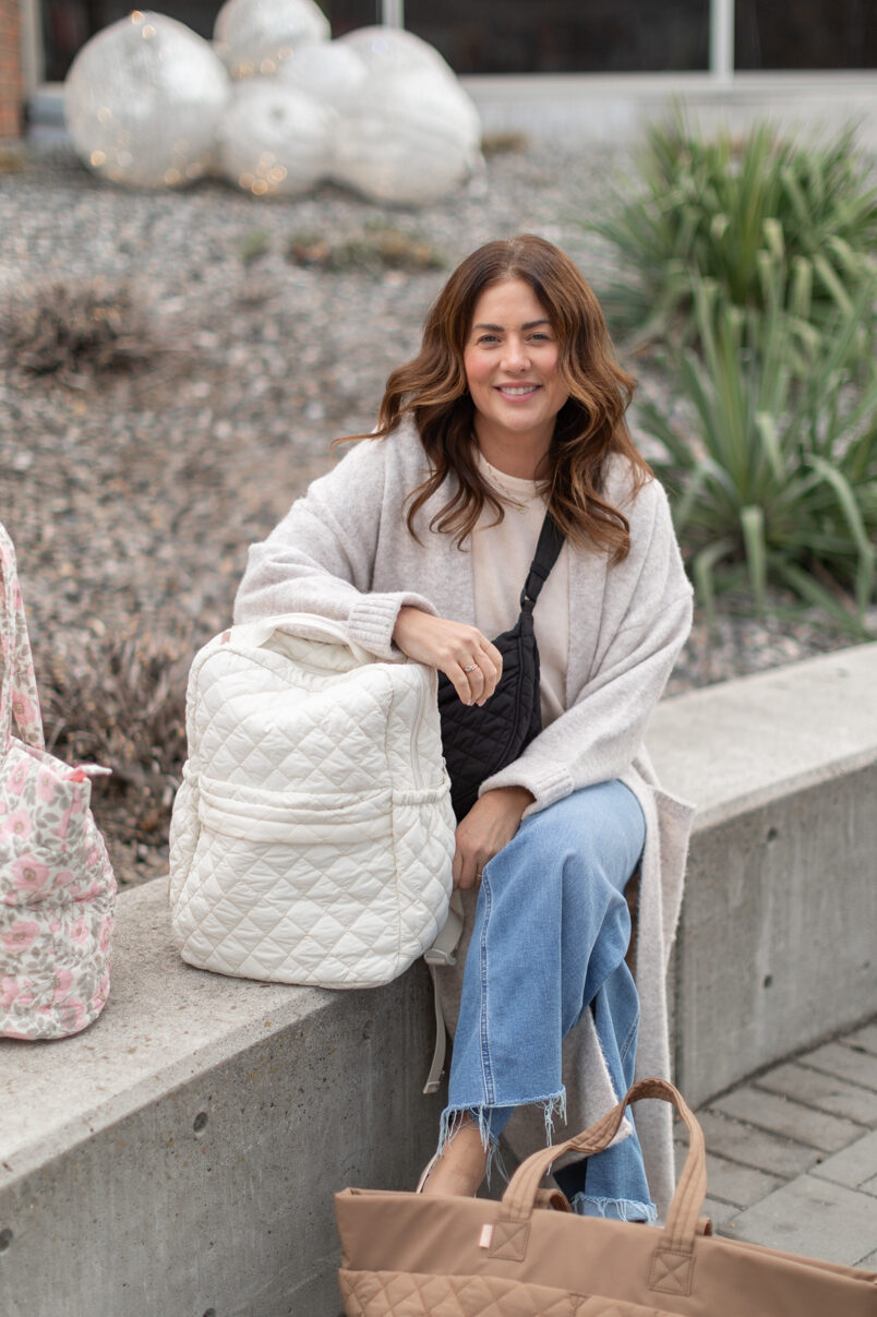 Jillian Harris sitting besides the Ela Handbags Backpack in cream