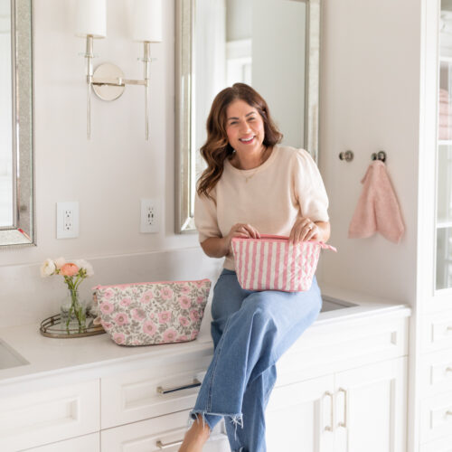 Jillian Harris holding cosmetic bags from Ela handbags collection