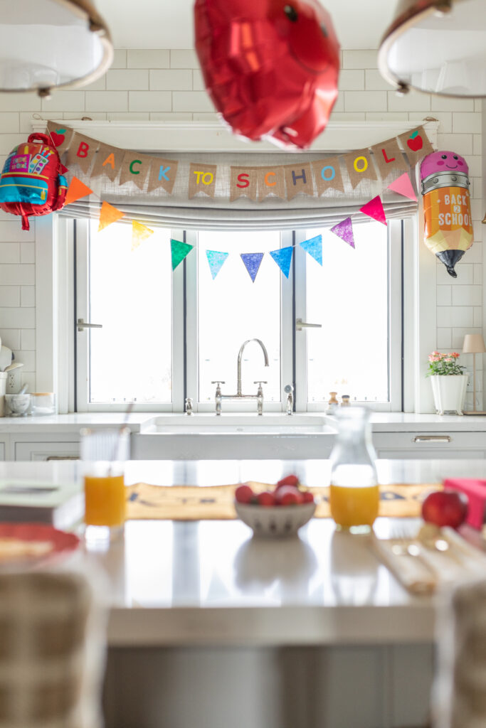 First day of school decor in kitchen with balloons and colourful banner.