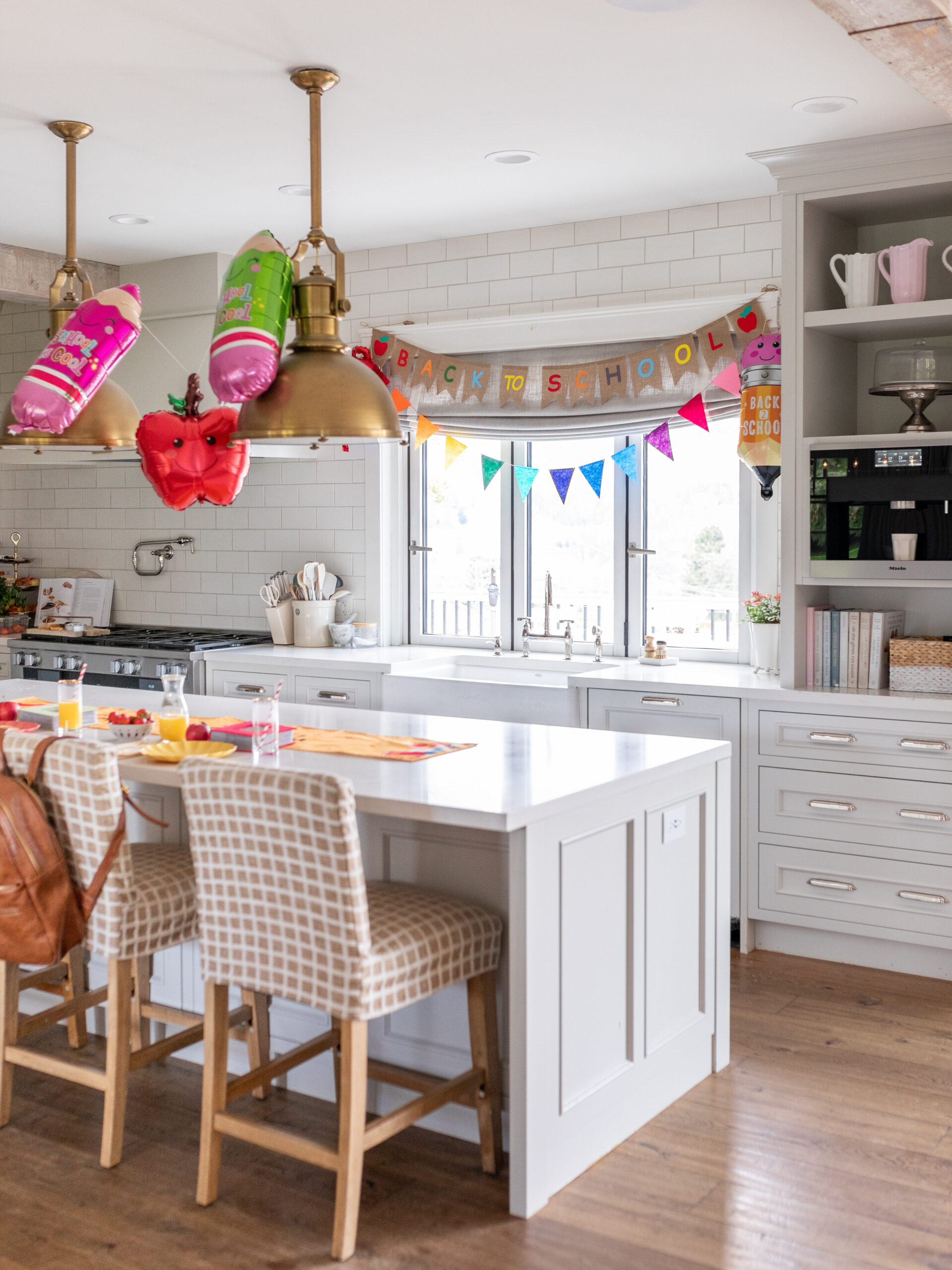 First day of school decor in kitchen with balloons and colourful banner.