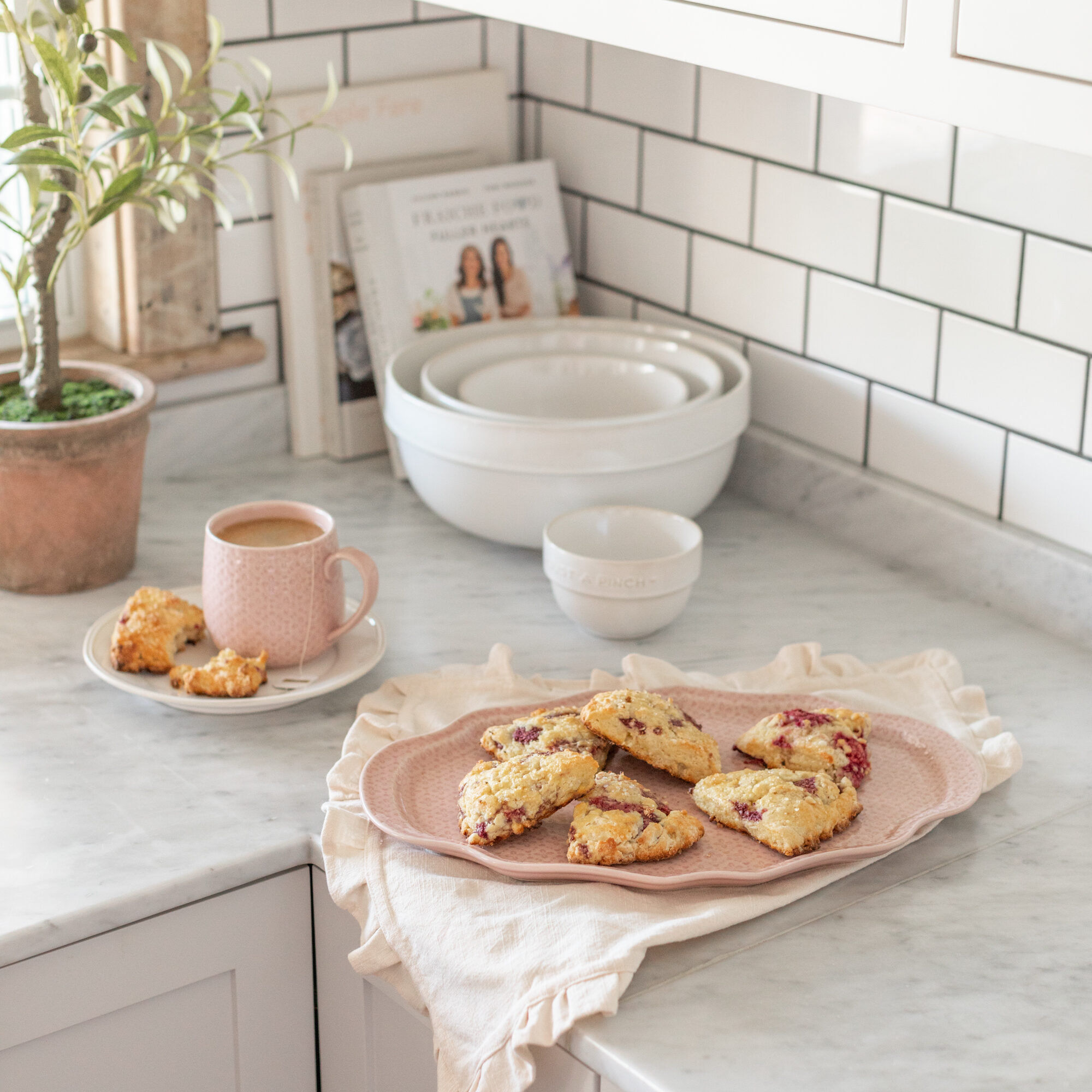 Cozy kitchen scene featuring scones on a pink plate and matching mug from the 2024 Jillian Harris x Joe Fresh x Life At Home™ Fall Collection.