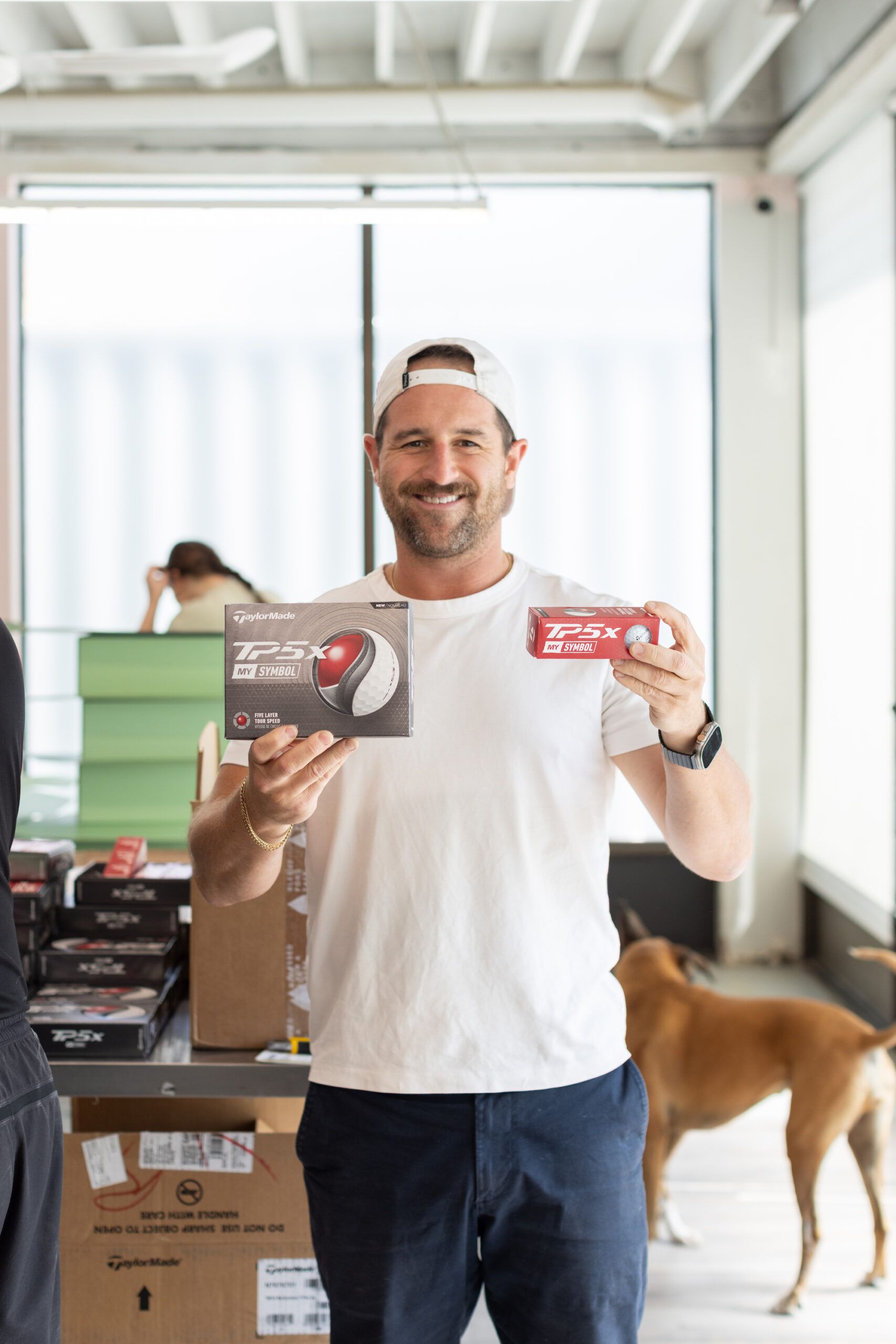 Justin holding the Titleist golf balls for their wedding welcome boxes.
