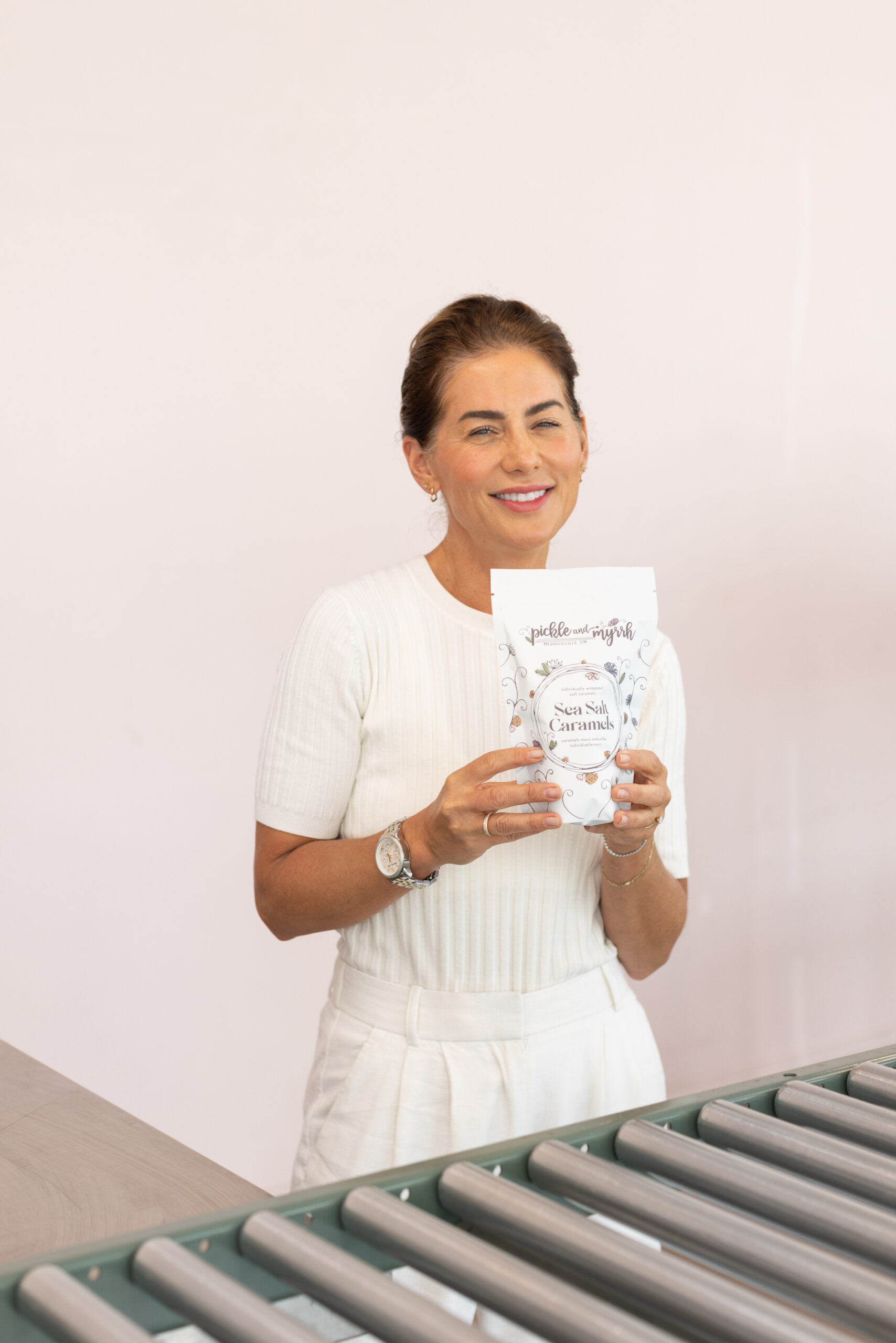 Jillian Harris holding Pickle & Myrhh Sea Salt Caramels