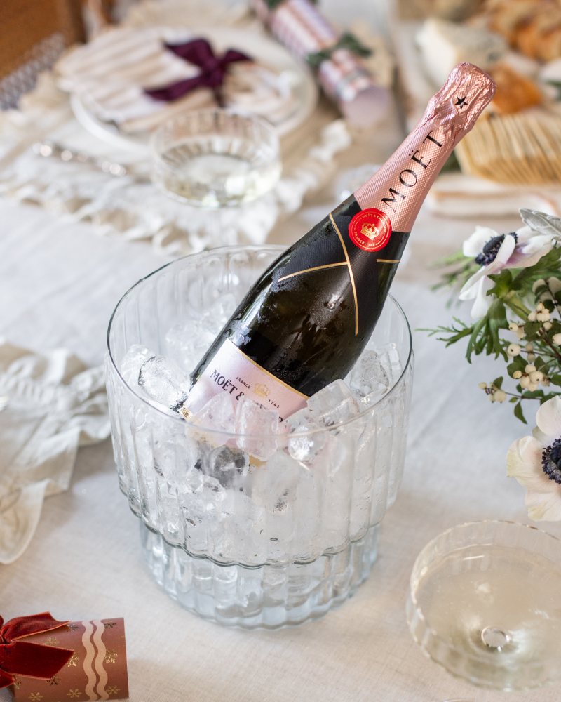 A bottle of Moet Chandon inside the Be Home Champagne Bucket on a decorated dinner table.