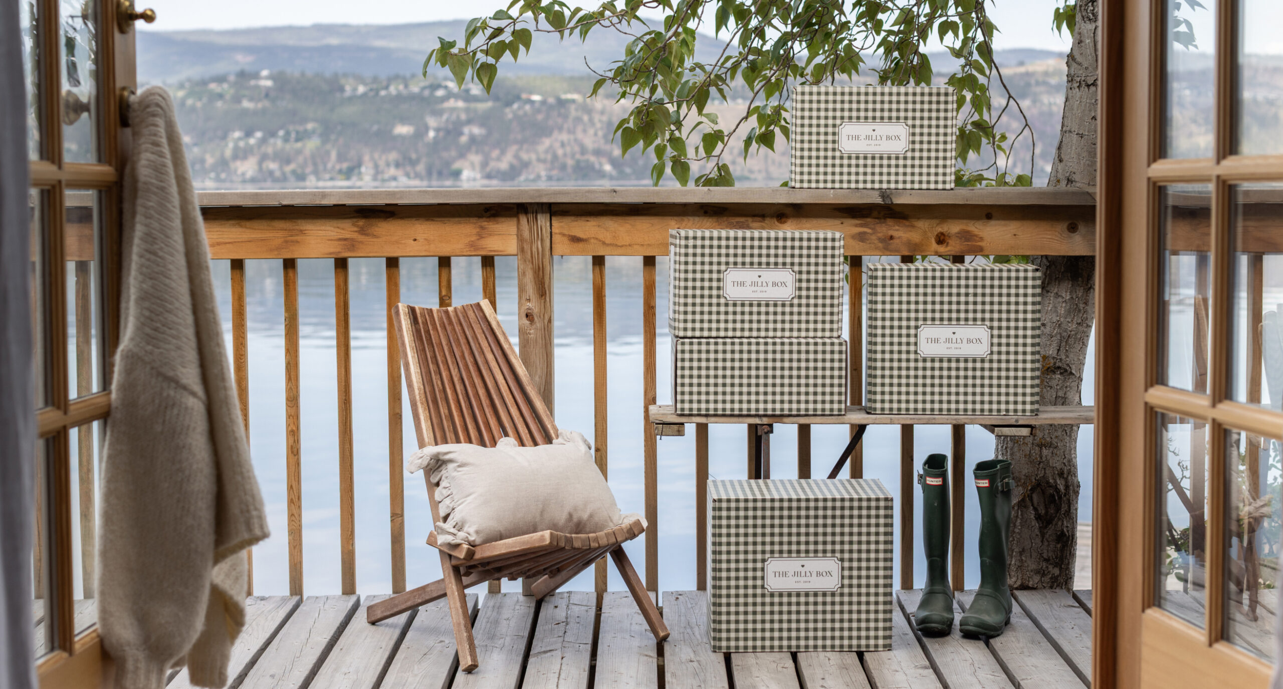 Fall 2026 Jilly Boxes on a patio by a chair and the sea in the background.